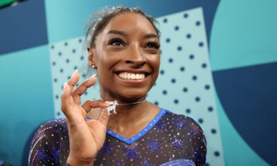 Simone Biles celebrates her gold medal with a diamond goat necklace