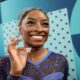 Simone Biles celebrates her gold medal with a diamond goat necklace