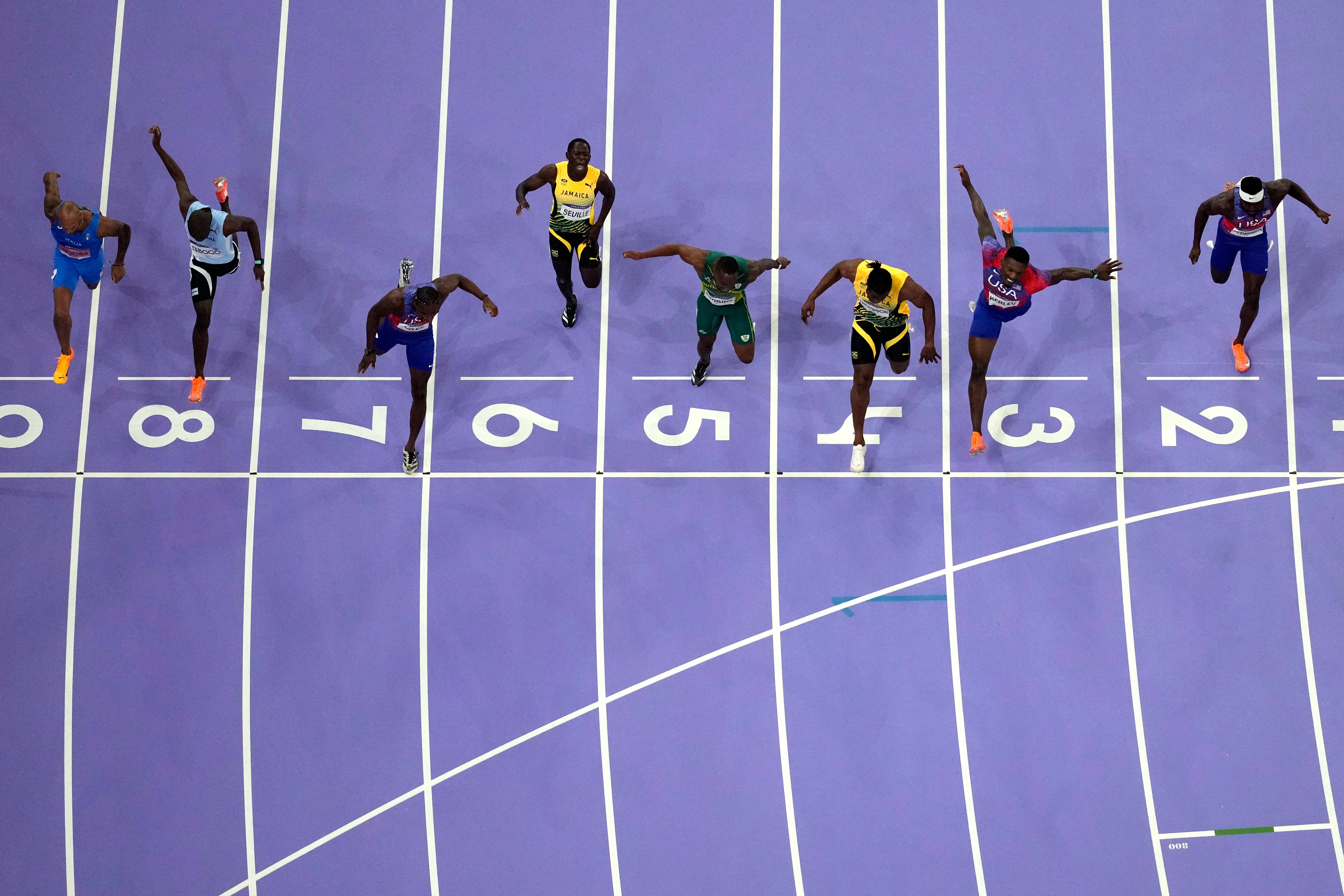 Lyles, in lane seven, crosses the line with Thomspon in lane four