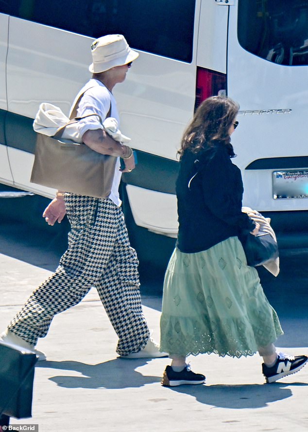 The Hollywood actor, 60, rocked a pair of baggy houndstooth trousers teamed with a white bucket hat and tan tote bag as he strolled towards his vehicle following his long trip home