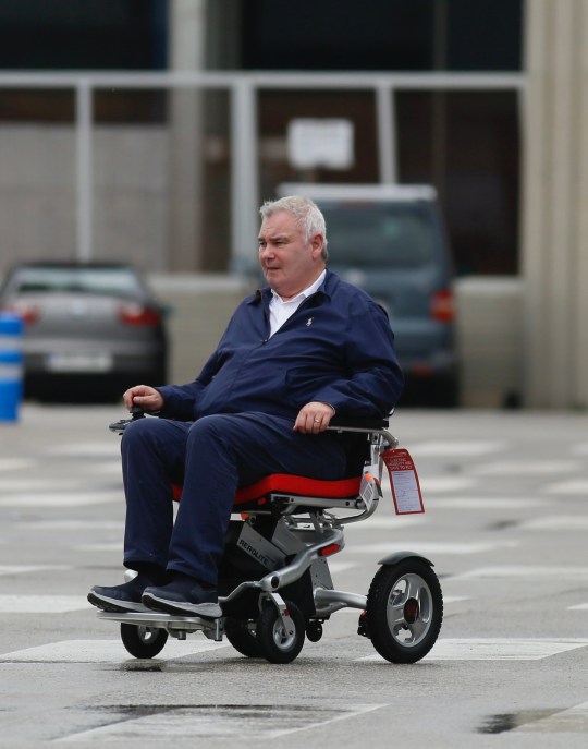 Eamonn Holmes using a wheelchair to travel through Barcelona Airport carpark