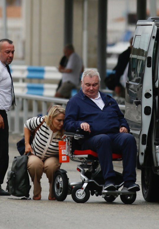 Katie Alexnader bending down to help with Eamonn Holmes' wheelchair