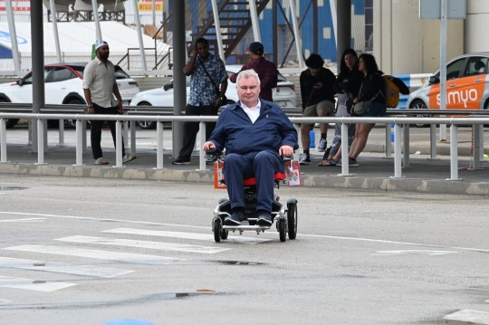 Eamonn Holmes steering himself through Barcelona Airport on a wheelchair 