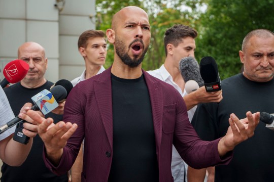 Andrew Tate gestures while speaking to the media after a hearing at the Bucharest Tribunal in Bucharest, Romania, Wednesday, Aug. 28, 2024. (AP Photo/Vadim Ghirda)