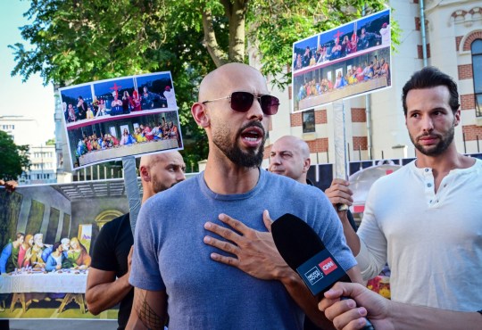 Andrew Tate (C) and his brother Tristan Tate (R) speak during a protest against the Olympics next to the French Embassy to Romania in Bucharest, on July 28, 2004. The Tate brothers criticezed the Paris 2024 Olympic Games for the inclusion message offered during the opening ceremony. They claim the opening ceremony was a mocking of Christianity and call the athletes for a boycott on the games. Andrew Tate, 37, and Tristan, 35, were arrested last December in Romania over allegations of rape, human trafficking and forming a criminal gang. (Photo by Daniel MIHAILESCU / AFP) (Photo by DANIEL MIHAILESCU/AFP via Getty Images)