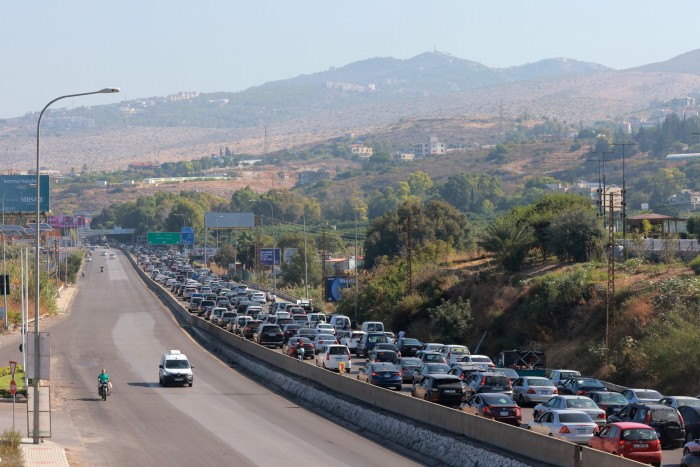 Vehicles wait in traffic in the town of Damour, south of the capital Beirut on September 24, 2024, as people flee southern Lebanon