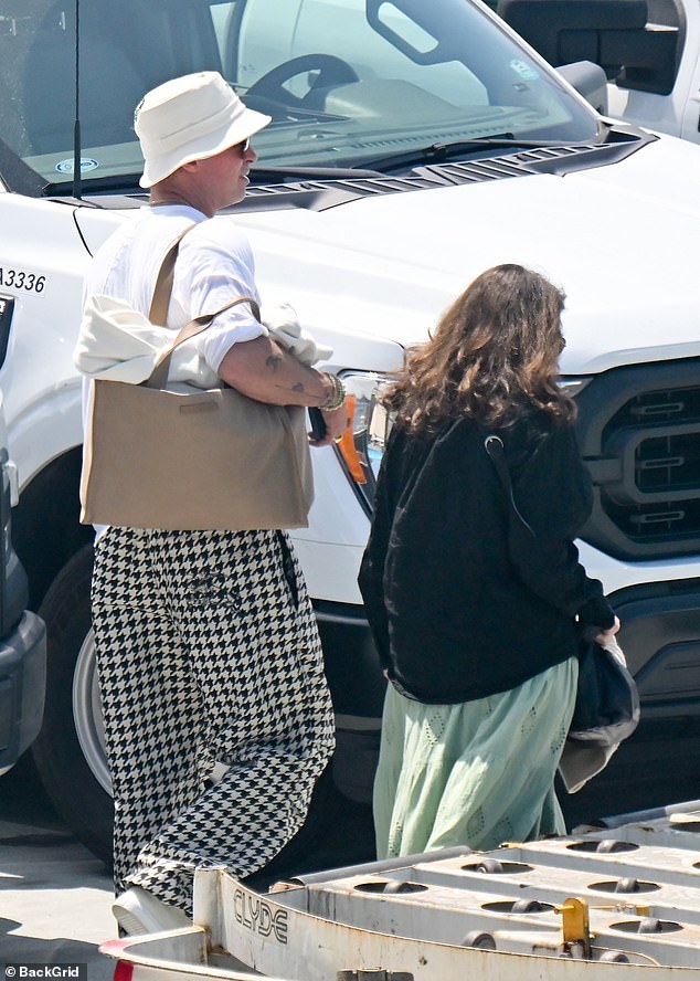 Brad Pitt ditched his sharp suits for a casual yet quirky ensemble as he touched down in Los Angeles on Monday following a whirlwind trip to Venice