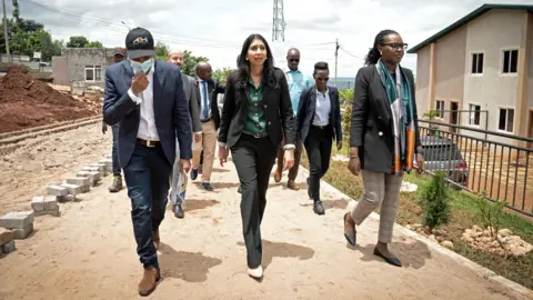 Getty Images Then-Home Secretary Suella Braverman tours a building site on the outskirts of Kigali during her visit to Rwanda in March 2023