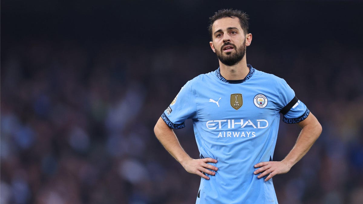 Manchester City forward Bernardo Silva standing with his hands on his hips.