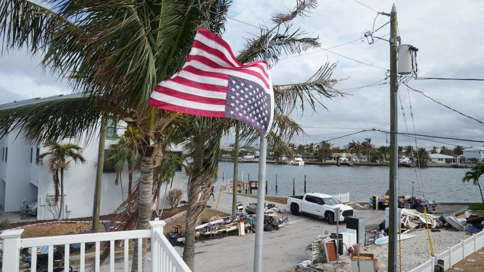 PHOTO: An American flag fly's upside down, the international sign for distress, at a home ahead of Hurricane Milton's expected landfall in the middle of this week in Treasure Island, Fla., Oct. 7, 2024.  (Bryan R. Smith/AFP via Getty Images)