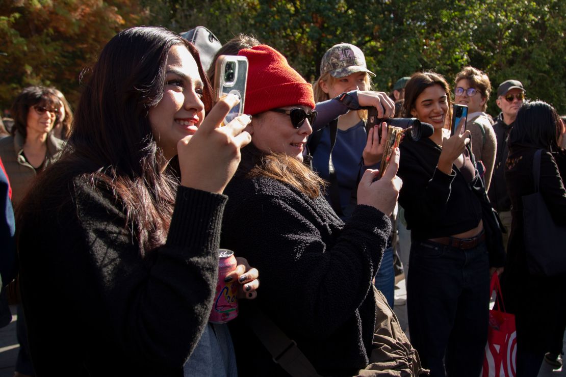 Alondra Maldonado, 19, left, takes photos of her boyfriend Reed Putnam as he gets interviewed.