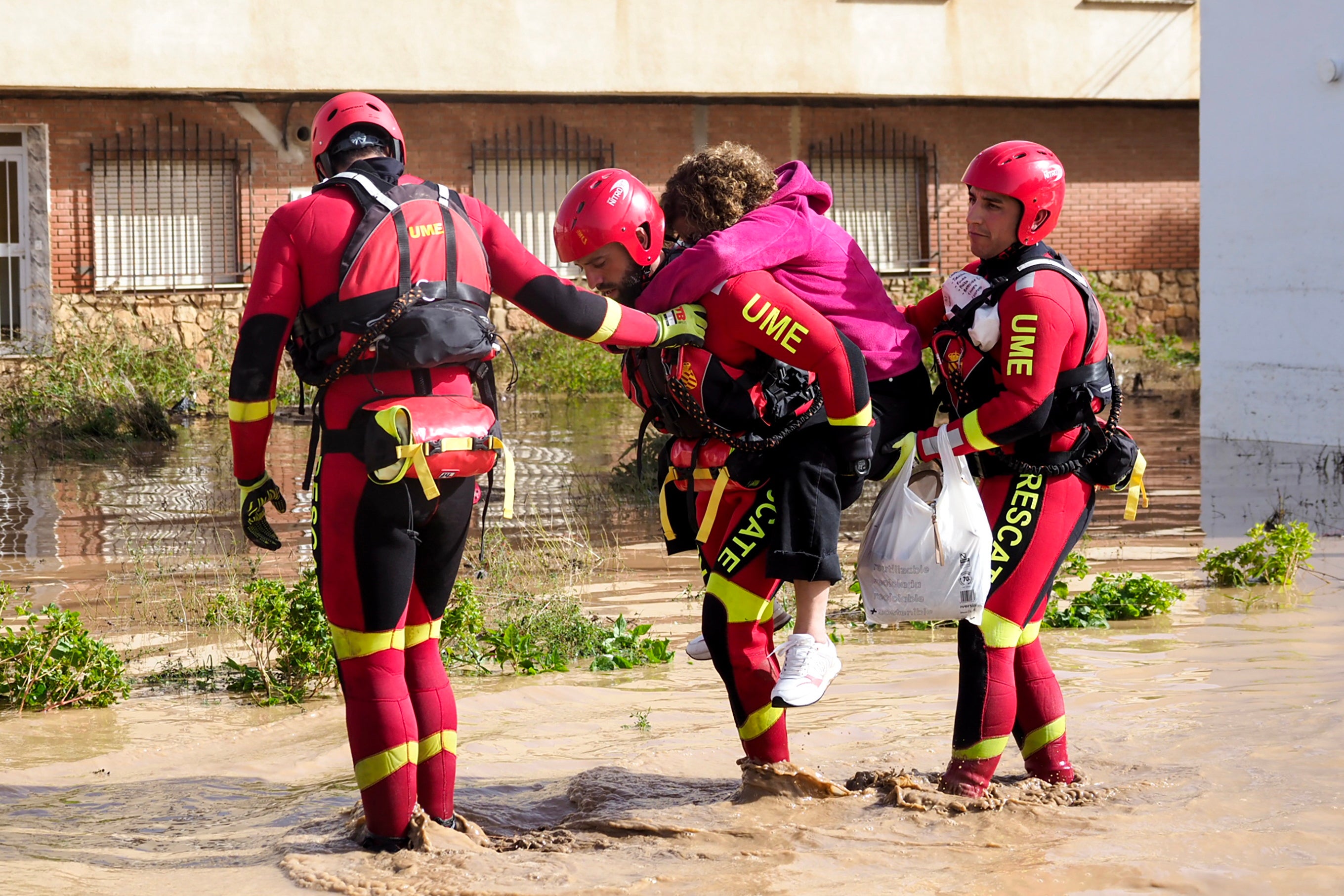 Members of the Spanish Emergency Military Unit (UME) help a resident in the flood-hit municipality of Mira, in the province of Cuenca