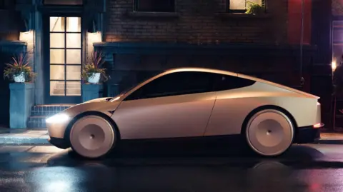 Courtesy of Tesla, Inc Tesla's Cybercab robotaxi parked on a dark, dimly lit street at the Warner Bros Studio in California