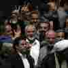 Palestinian Hamas chief Ismail Haniyeh, center, flashes a victory sign as he is surrounded by a group of Iranian lawmakers after the conclusion of the swearing-in ceremony of newly-elected Iranian President Masoud Pezeshkian at the parliament in Tehran, Iran, Tuesday, 30, 2024.