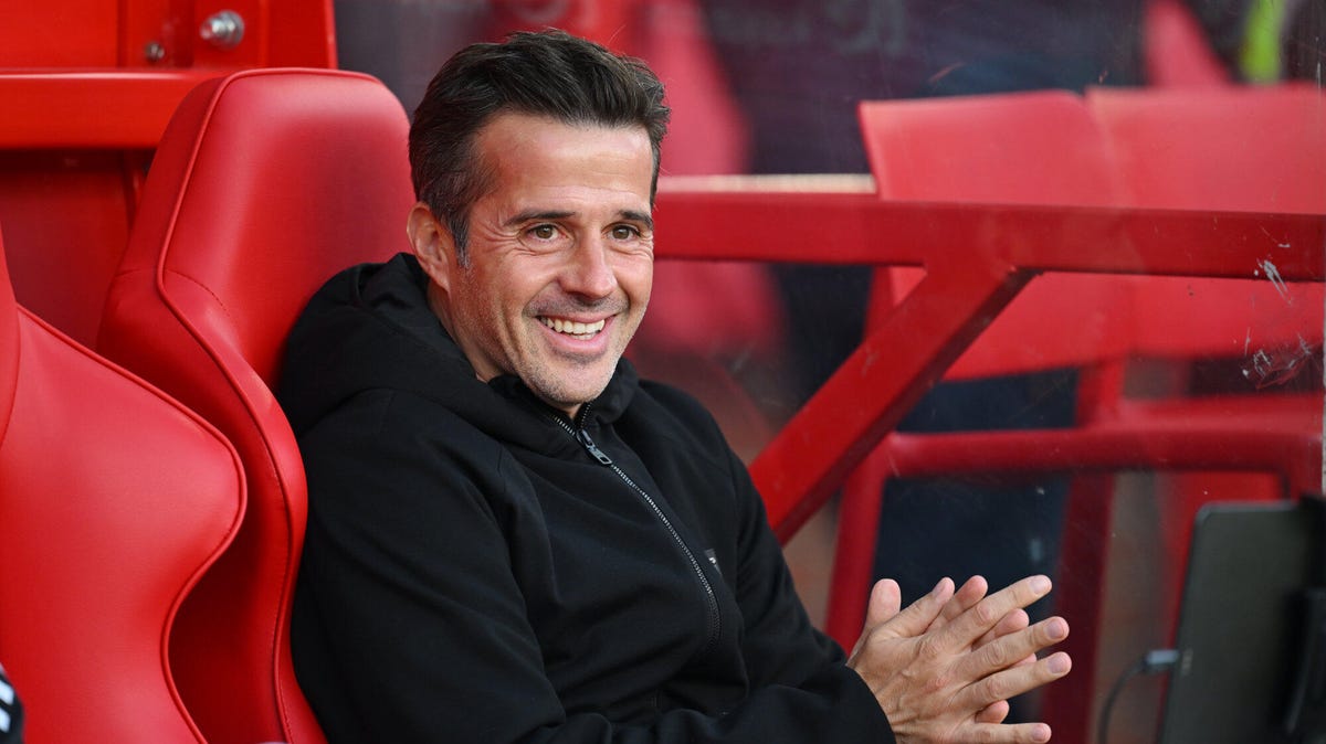 Fulham manager Marco Silva smiling, sitting in a red chair.