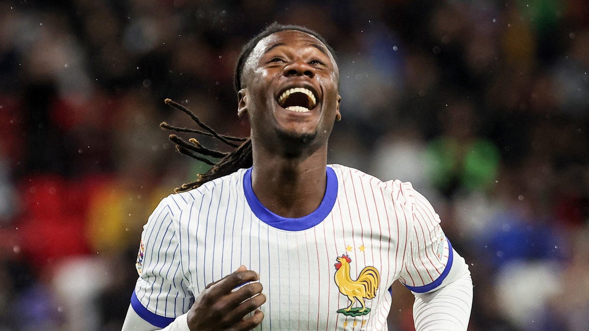 France midfielder Eduardo Camavinga running, celebrating, smiling, with his head leaning back.