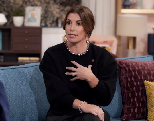 Coleen Rooney on This Morning, wearing all black and holding her hand to her chest as she talks