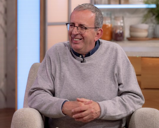 Reverend Richard Coles on Lorraine in 2023, smiling and wearing a grey jumper