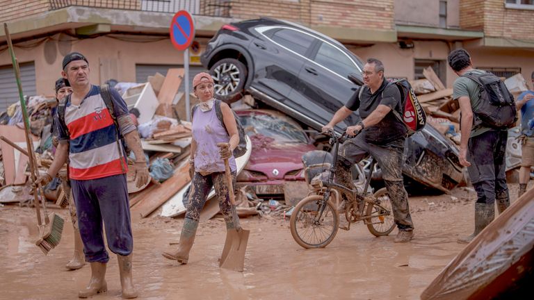 People walk through an area affected by floods in Catarroja, Spain.
Pic: AP