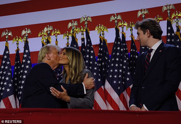 Barron wore a sharp black suit, red-and-blue striped tie, and an American flag pin on his lapel