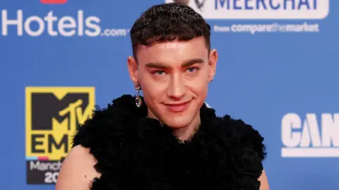 Reuters Olly Alexander in front of a blue background on the MTV Awards red carpet