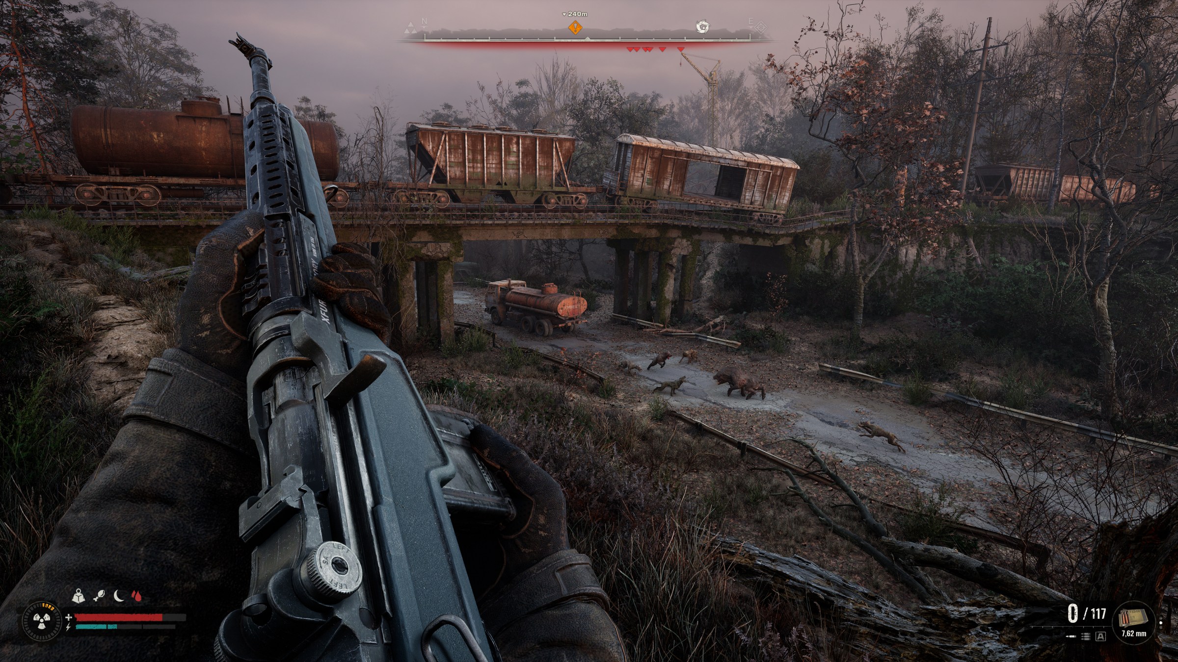 Two packs of mutants engage in a viaduct as the player looks on from a hillside in STALKER 2: Heart of Chornobyl.