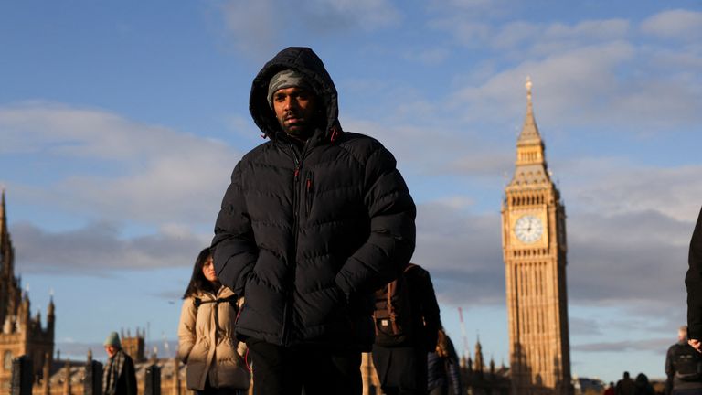 Commuters dressed in warm clothes walk over Westminster Bridge.
Pic: Reuters