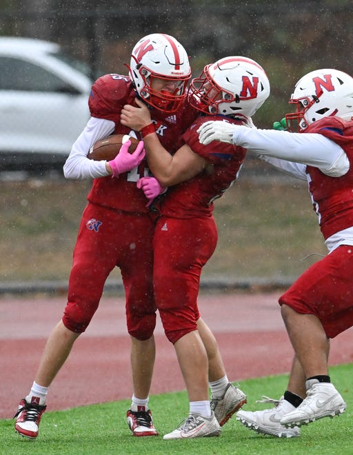 Natick junior James Mortarelli celebrates a touchdown with teammates unior Jonathan Chase and senior Jordi Carias during the annual Thanksgiving Day football game at Memorial Field in Natick, Thursday, Nov. 28, 2024. Natick High School defeated Framingham High School 42-15.