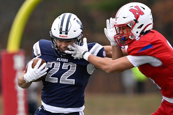 Framingham sophomore Nick Duarte carries the ball while pressured by Natick senior Nolan Cloutier during the annual Thanksgiving Day football game at Memorial Field in Natick, Thursday, Nov. 28, 2024. Natick High School defeated Framingham High School 42-15.