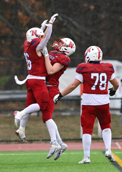 Natick senior Sam Hubbard celebrates a touchdown with teammates senior James Perrier and sophomore Griffin Martell during the annual Thanksgiving Day football game at Memorial Field in Natick, Thursday, Nov. 28, 2024. Natick High School defeated Framingham High School 42-15.