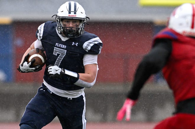 Framingham sophomore Eli Rosen runs the ball while pressured by Natick senior Owen Denver during the annual Thanksgiving Day football game at Memorial Field in Natick, Thursday, Nov. 28, 2024. Natick High School defeated Framingham High School 42-15.