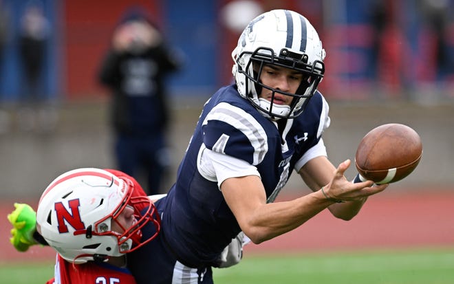 Framingham senior captain Matheus Silva tosses the ball before getting tackled by Natick senior Jack Showstead during the annual Thanksgiving Day football game at Memorial Field in Natick, Thursday, Nov. 28, 2024. Natick High School defeated Framingham High School 42-15.