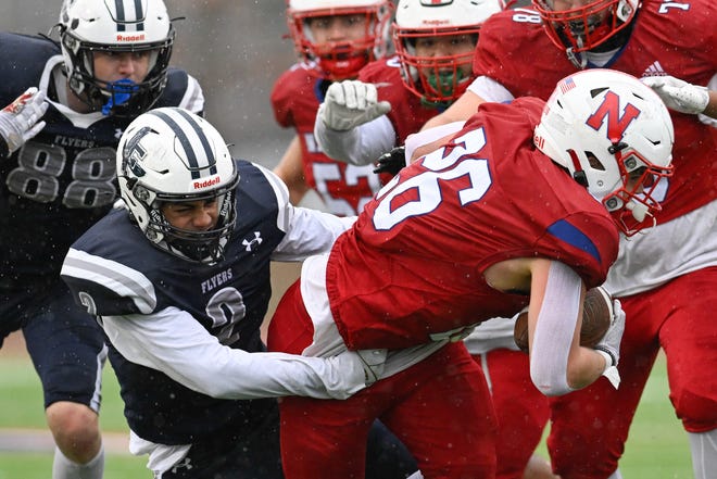 Framingham senior Michael Pusateri tackles Natick senior Sam Hubbard as he carries the ball during the annual Thanksgiving Day football game at Memorial Field in Natick, Thursday, Nov. 28, 2024. Natick High School defeated Framingham High School 42-15.