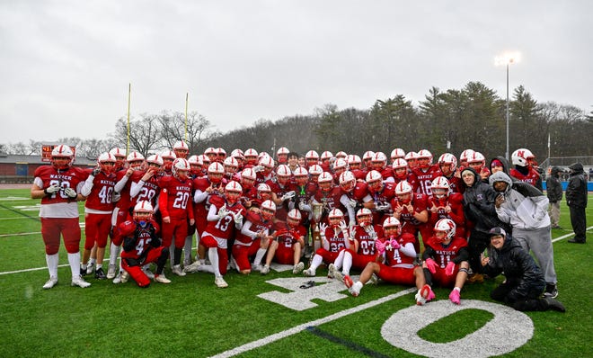 Natick varsity footballs pose for a photo with the Elks trophy after defeating Framingham, 42-15, during the annual Thanksgiving Day football game at Memorial Field in Natick, Thursday, Nov. 28, 2024.