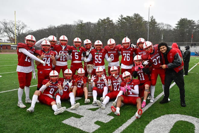 Natick varsity football seniors pose for a photo with the Elks trophy after defeating Framingham, 42-15, during the annual Thanksgiving Day football game at Memorial Field in Natick, Thursday, Nov. 28, 2024.