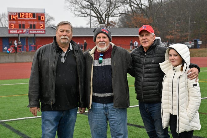 Left to right, members of the Natick High School 1974 Super Bowl team Jim Dale, Bob Naranjo, Tim Whelan (Natick Class of 1972 and former Natick coach Bob Whelan's son) and Julia Pennock (Bob Whelan's great granddaughter) are recognized at the end of the first half during the annual Thanksgiving Day football game against Natick at Memorial Field in Natick, Thursday, Nov. 28, 2024. Natick High School defeated Framingham High School 43-15.