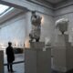 An employee poses as he views examples of the Parthenon sculptures, sometimes referred to in the UK as the Elgin Marbles, on display at the British Museum in London, Britain, January 25, 2023. REUTERS/Toby Melville