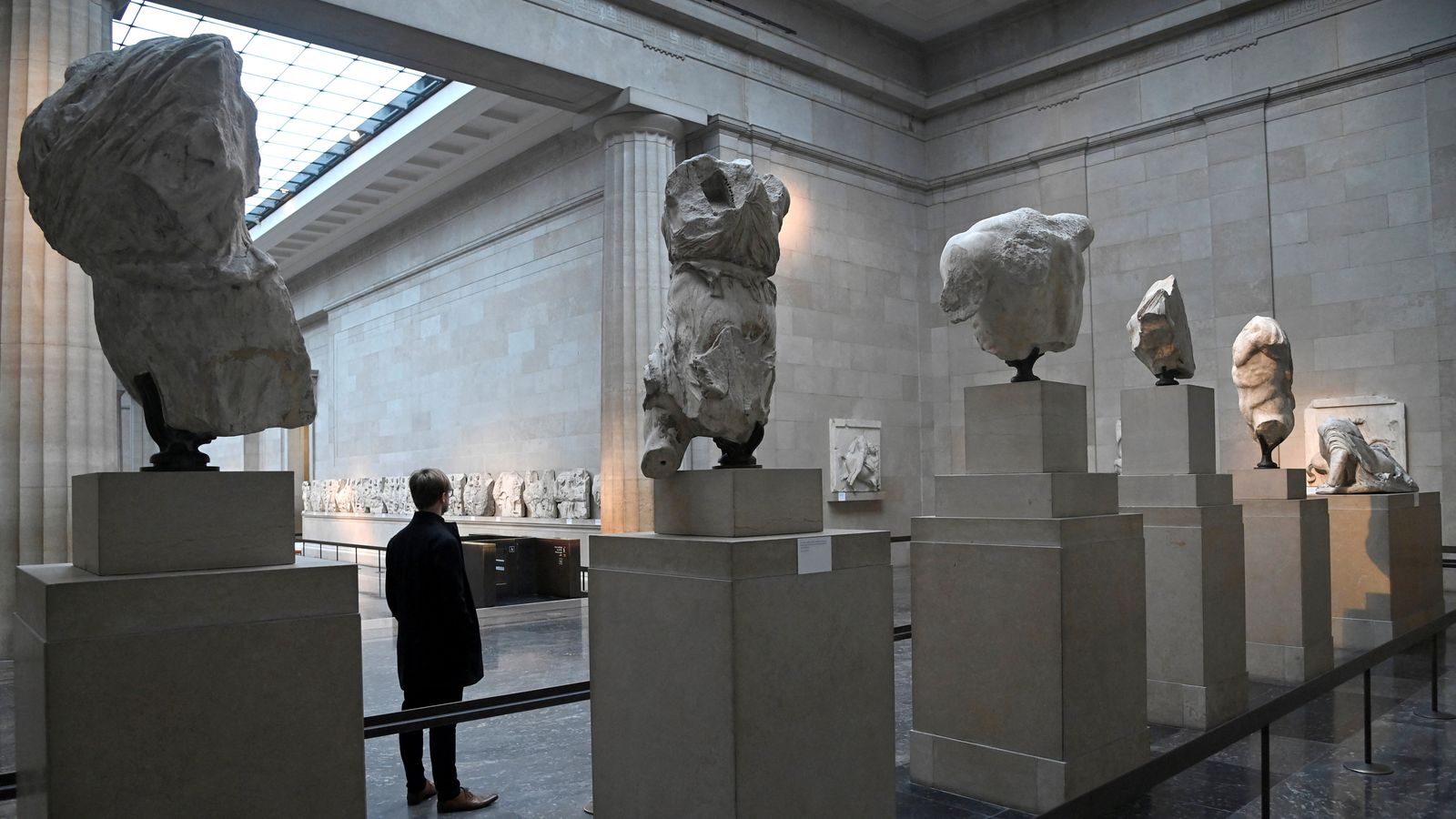 An employee poses as he views examples of the Parthenon sculptures, sometimes referred to in the UK as the Elgin Marbles, on display at the British Museum in London, Britain, January 25, 2023. REUTERS/Toby Melville