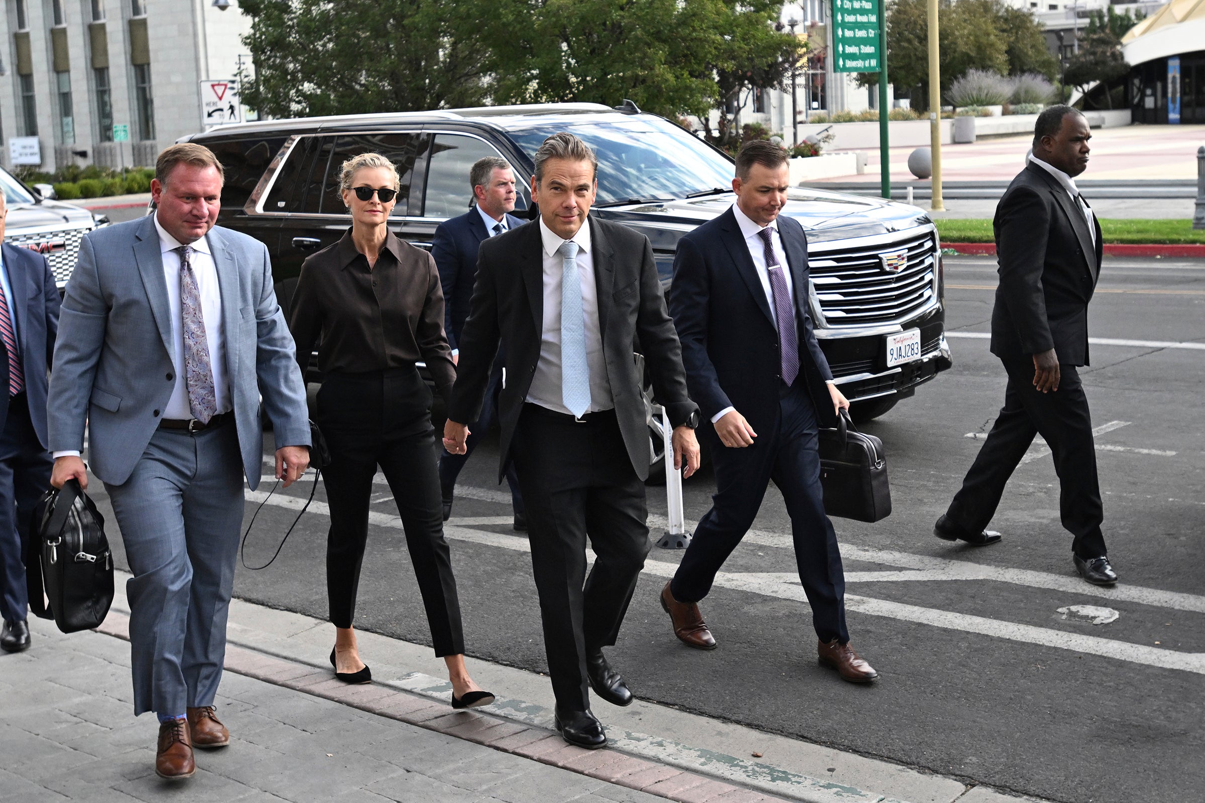 Lachlan Murdoch, center, and his wife Sarah arrive at the court in September