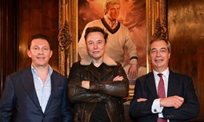 The three men stand below a portrait of a young Donald Trump wearing cricket gear