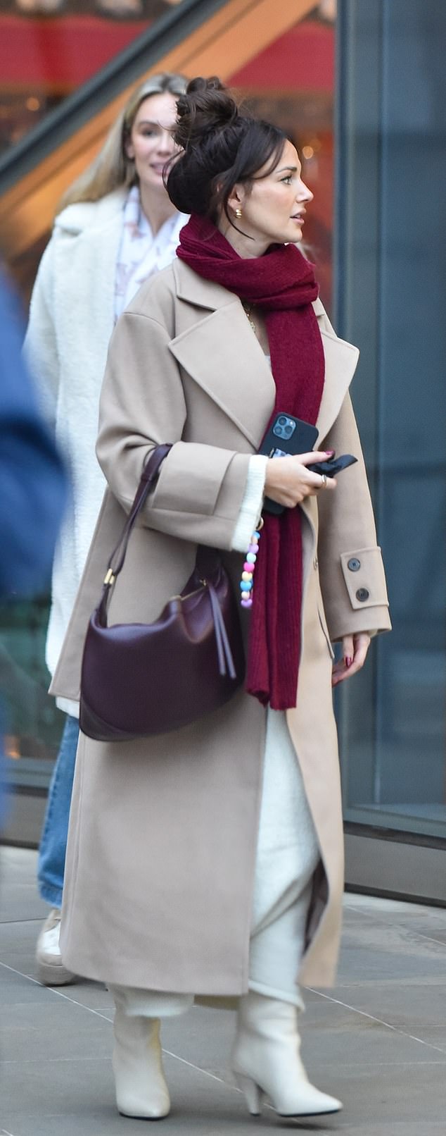 Michelle concealed her baby bump earlier this month by wearing a long beige coat and scarf, completing her look white white boots and a maroon bag