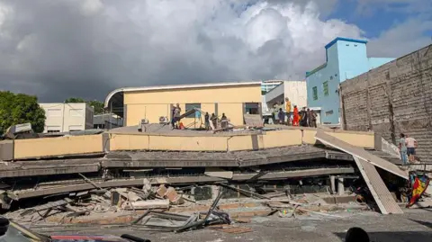 Getty Images Rescue workers are seen at the site of a collapsed building after a powerful earthquake struck Port Vila, the capital city of Vanuatu, on December 17, 2024