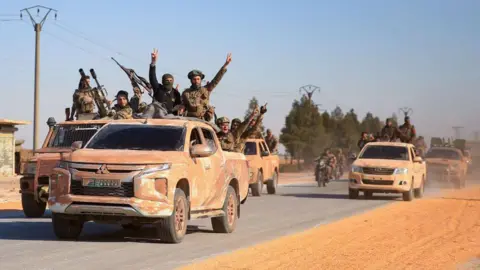 Getty Images Anti government groups drive a convoy near eastern Aleppo