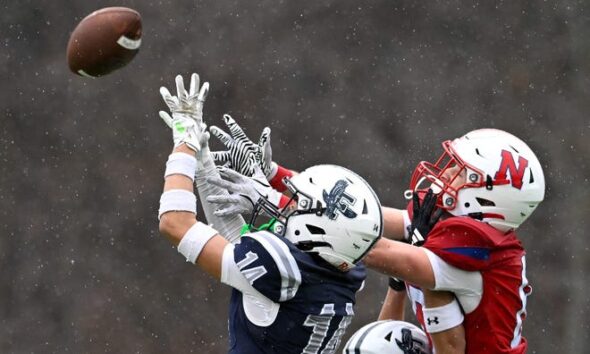 Framingham junior Kolven McBrayer makes an interceptoin on a pass intended for Natick senior Simon Pedrelli during the annual Thanksgiving Day football game at Memorial Field in Natick, Thursday, Nov. 28, 2024. Natick High School defeated Framingham High School 42-15.