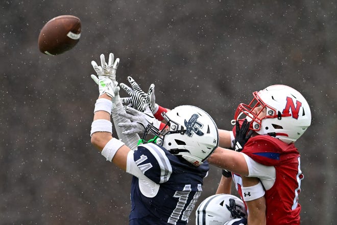 Framingham junior Kolven McBrayer makes an interceptoin on a pass intended for Natick senior Simon Pedrelli during the annual Thanksgiving Day football game at Memorial Field in Natick, Thursday, Nov. 28, 2024. Natick High School defeated Framingham High School 42-15.