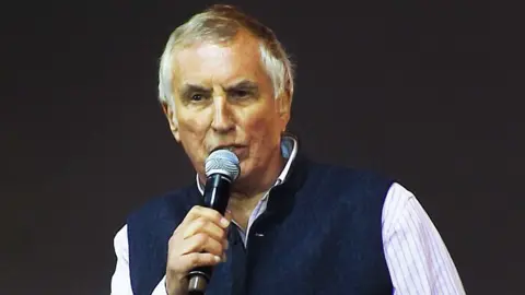 Getty Images Johnny Walker speaking into a microphone on stage at the BBC Radio 2 Festival In A Day at Hyde Park on September 8, 2013