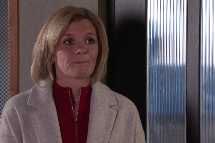 Jane Danson as Leanne Battersby in a cream coat and red top