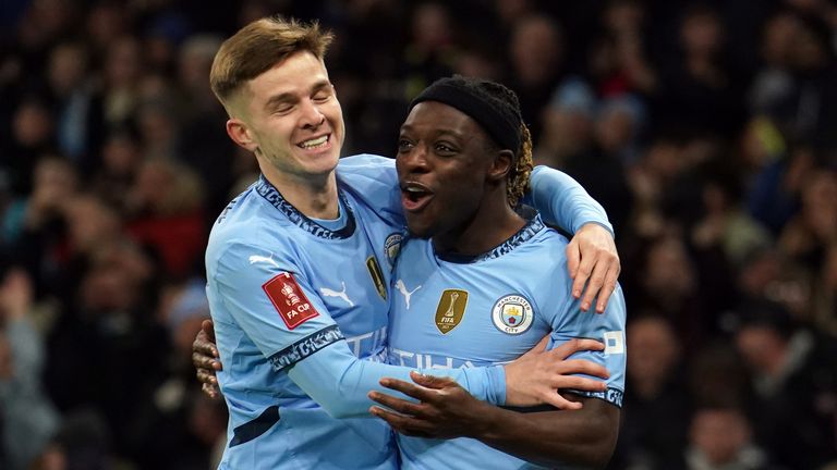 Manchester City's Jeremy Doku celebrates scoring the opening goal against Salford City with James McAtee