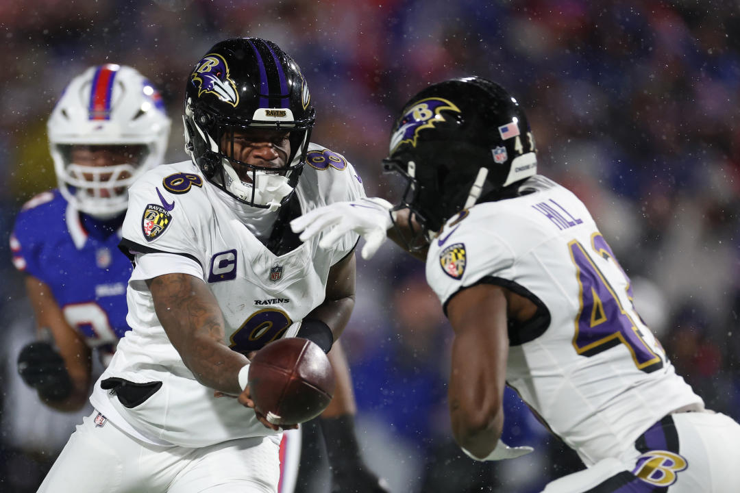 ORCHARD PARK, NEW YORK - JANUARY 19: Lamar Jackson #8 of the Baltimore Ravens hands the ball off to Justice Hill #43 against the Buffalo Bills in the first quarter during the AFC Divisional Playoff at Highmark Stadium on January 19, 2025 in Orchard Park, New York.  (Photo by Al Bello/Getty Images)